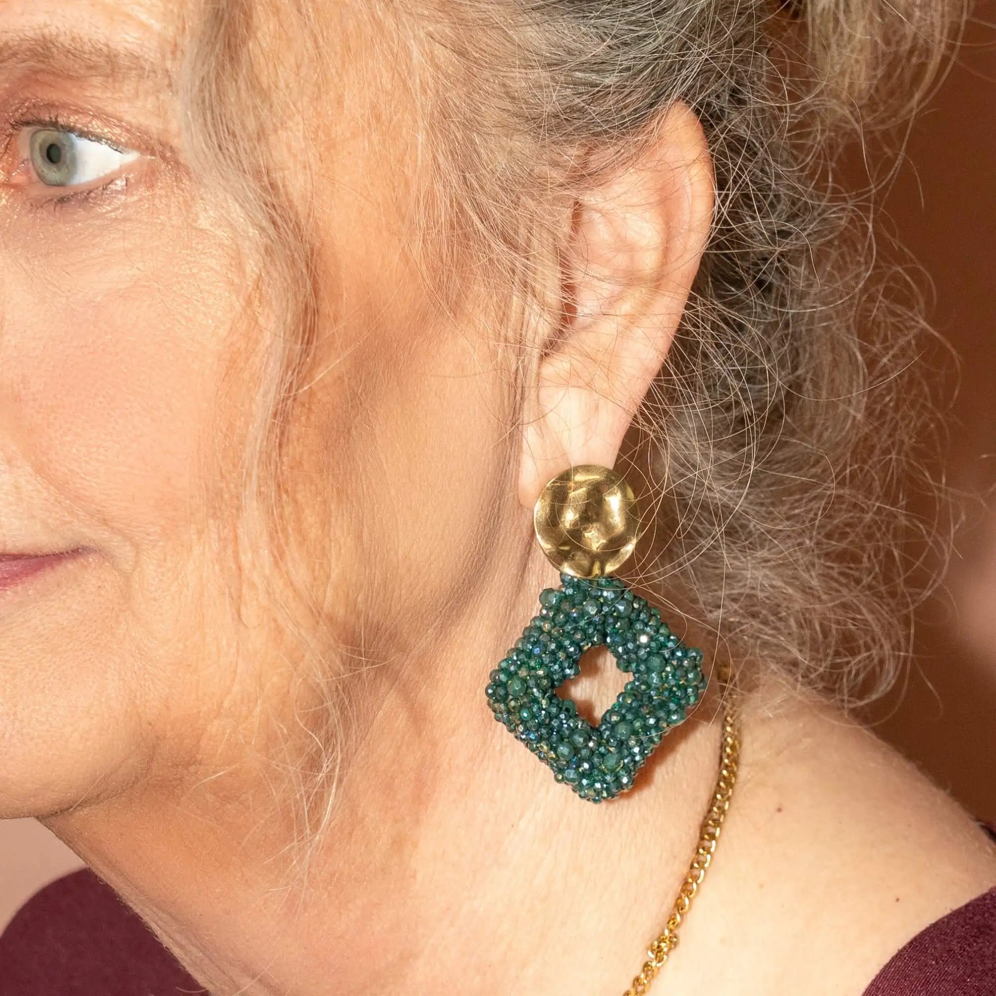 Model met Beaded Diamonds groen – statement oorbellen in het groen met ruitvorm voor een opvallende look.