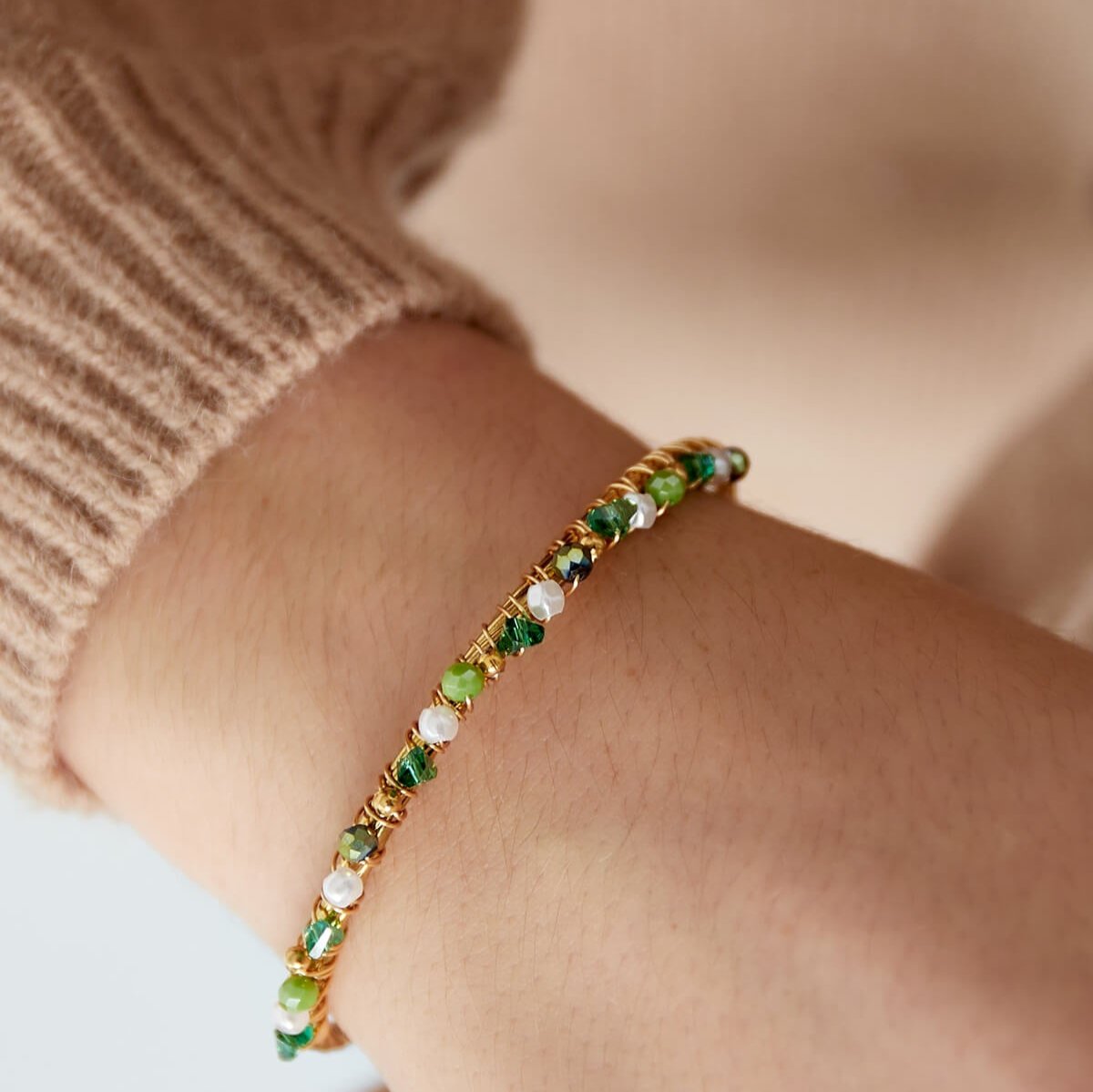 Vrouw met de verstelbare groene Beady Bangle armband, gemaakt van roestvrij staal.