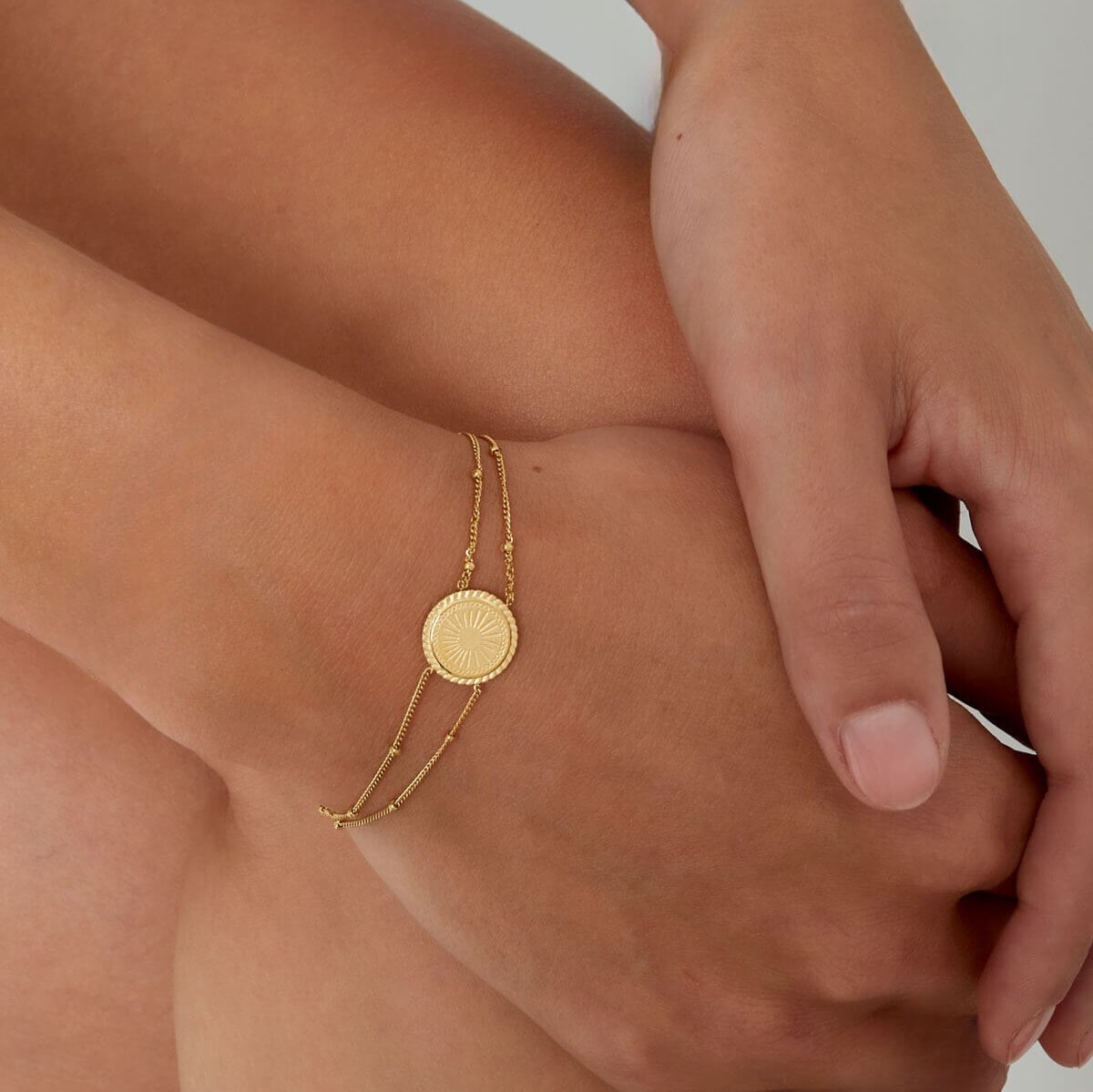 Gouden roestvrij stalen armband met ronde bedel, close-up