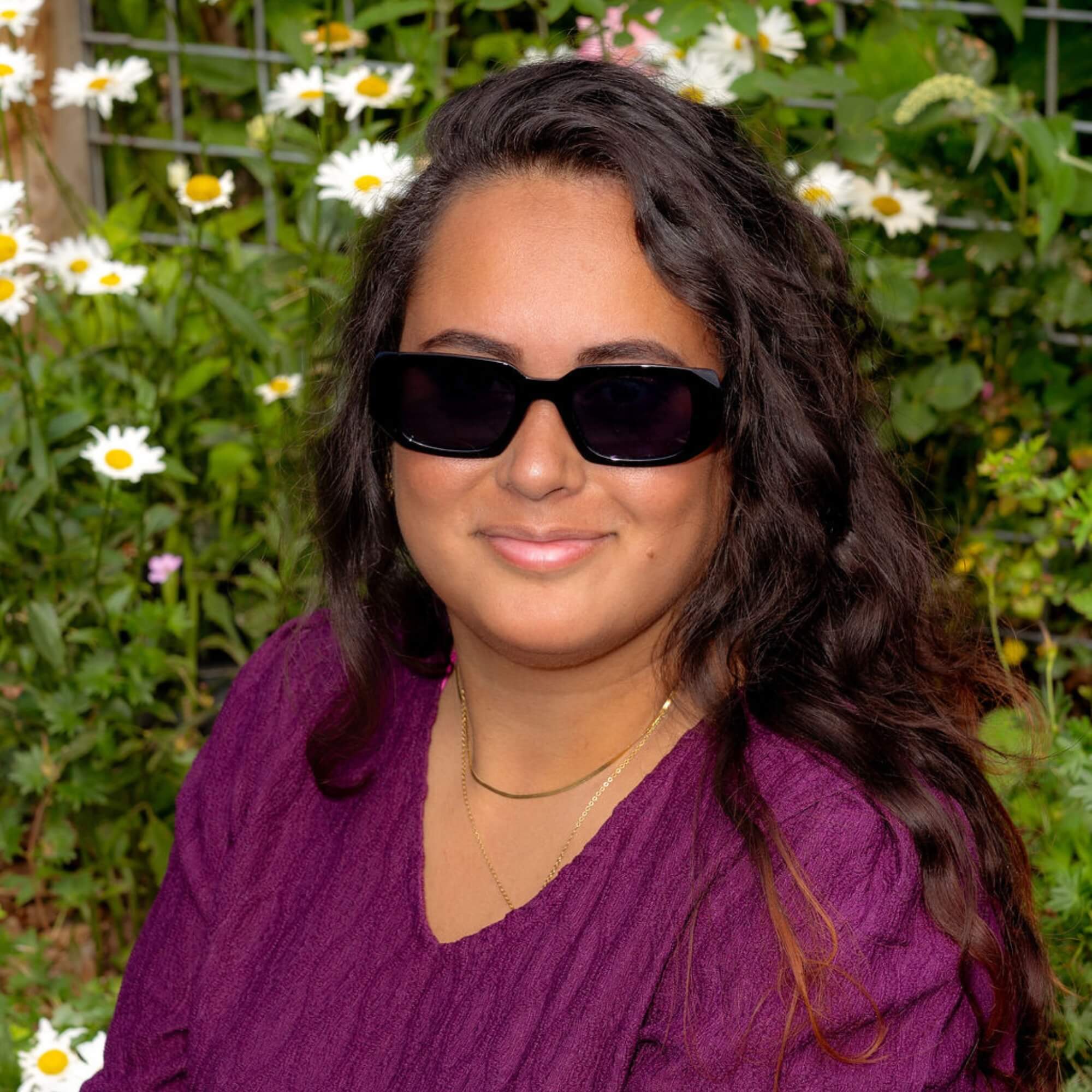 Celia draagt de Looking Sharp Zonnebril zwart - een mooie zwarte retro zonnebril die zelfvertrouwen uitstraalt.