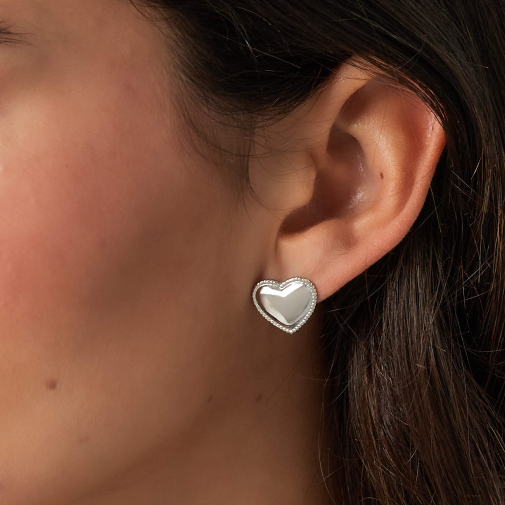 Model showt zilveren minimalistische hartjes oorbellen, roestvrij stalen studs.