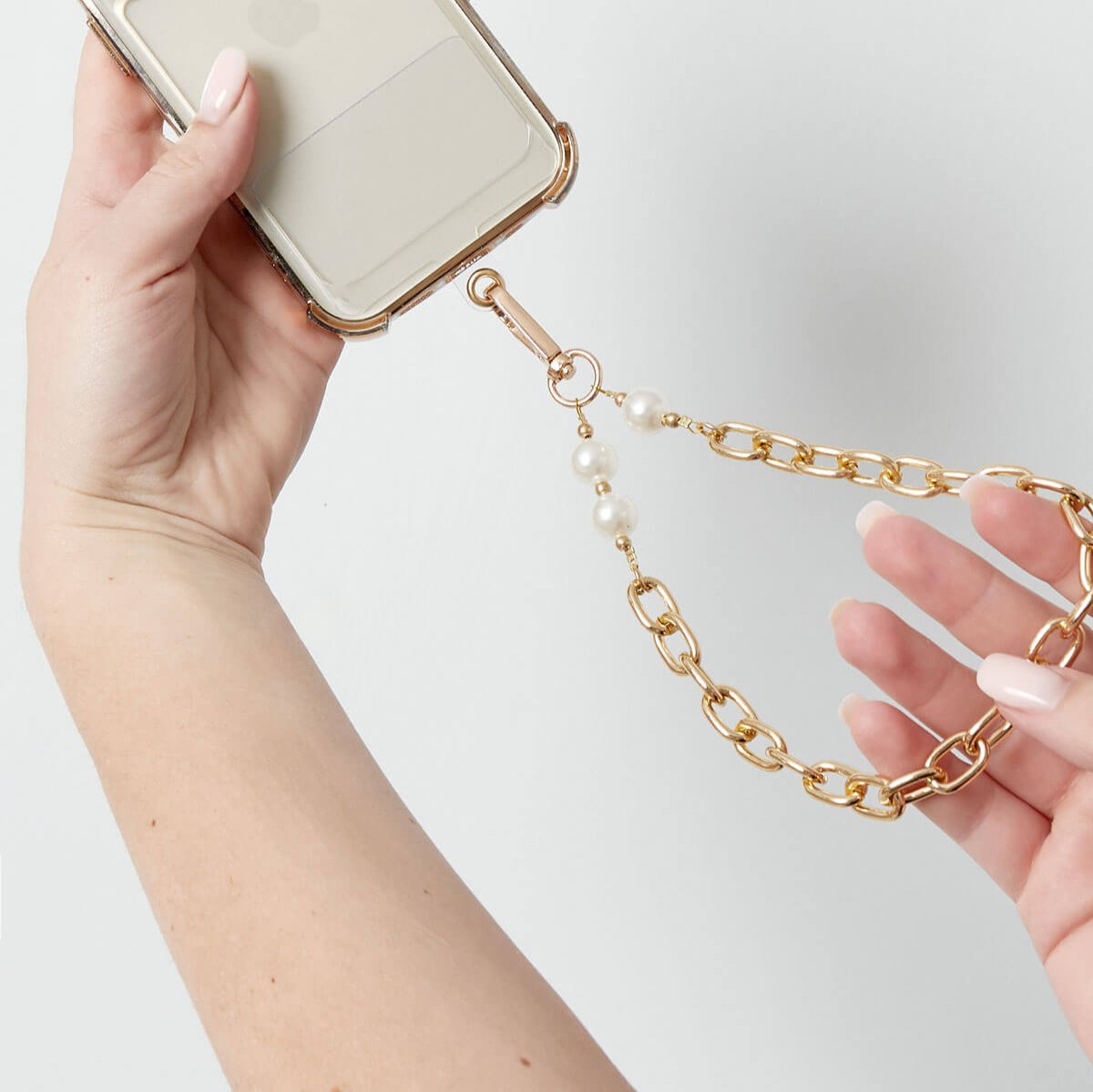 Model draagt Call Me Chic Telefoonkoord kort goud — chic telefoonkoord kort, schakels design voor vrouwen, zonder speciaal telefoonhoesje.