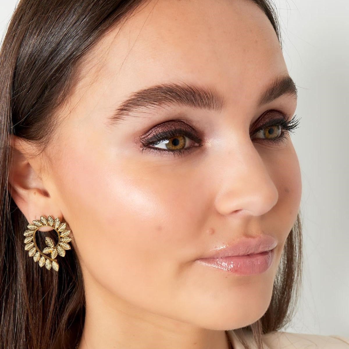 Model draagt Leaf Me Be Oorbellen – gouden oorbellen met bladeren voor vrouwen, een stijlvolle touch voor elke dag.