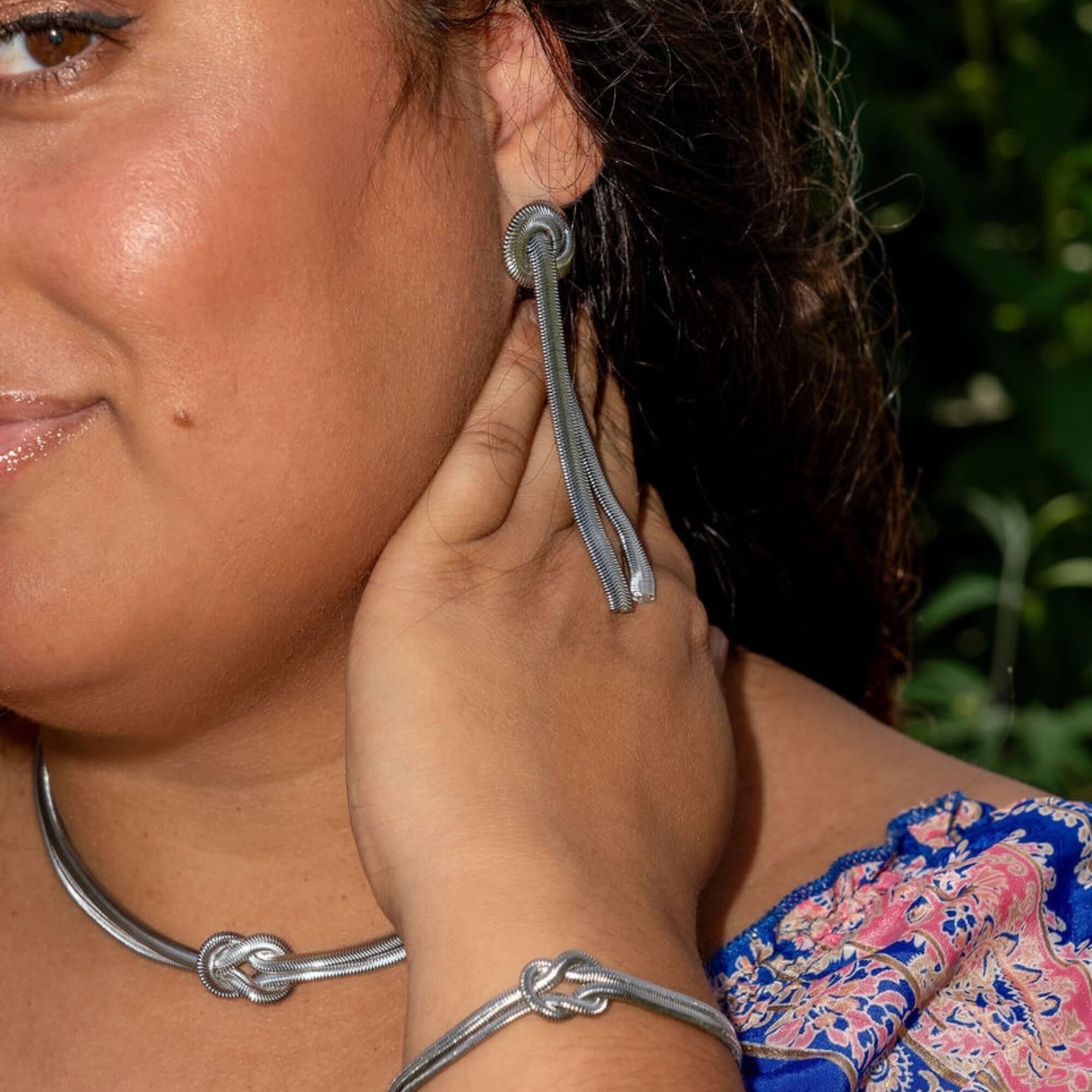 Model met Bound by Beauty Oorbellen in zilver – zilveren dames oorbellen met knoopdesign, hypoallergeen en perfect voor elke gelegenheid.