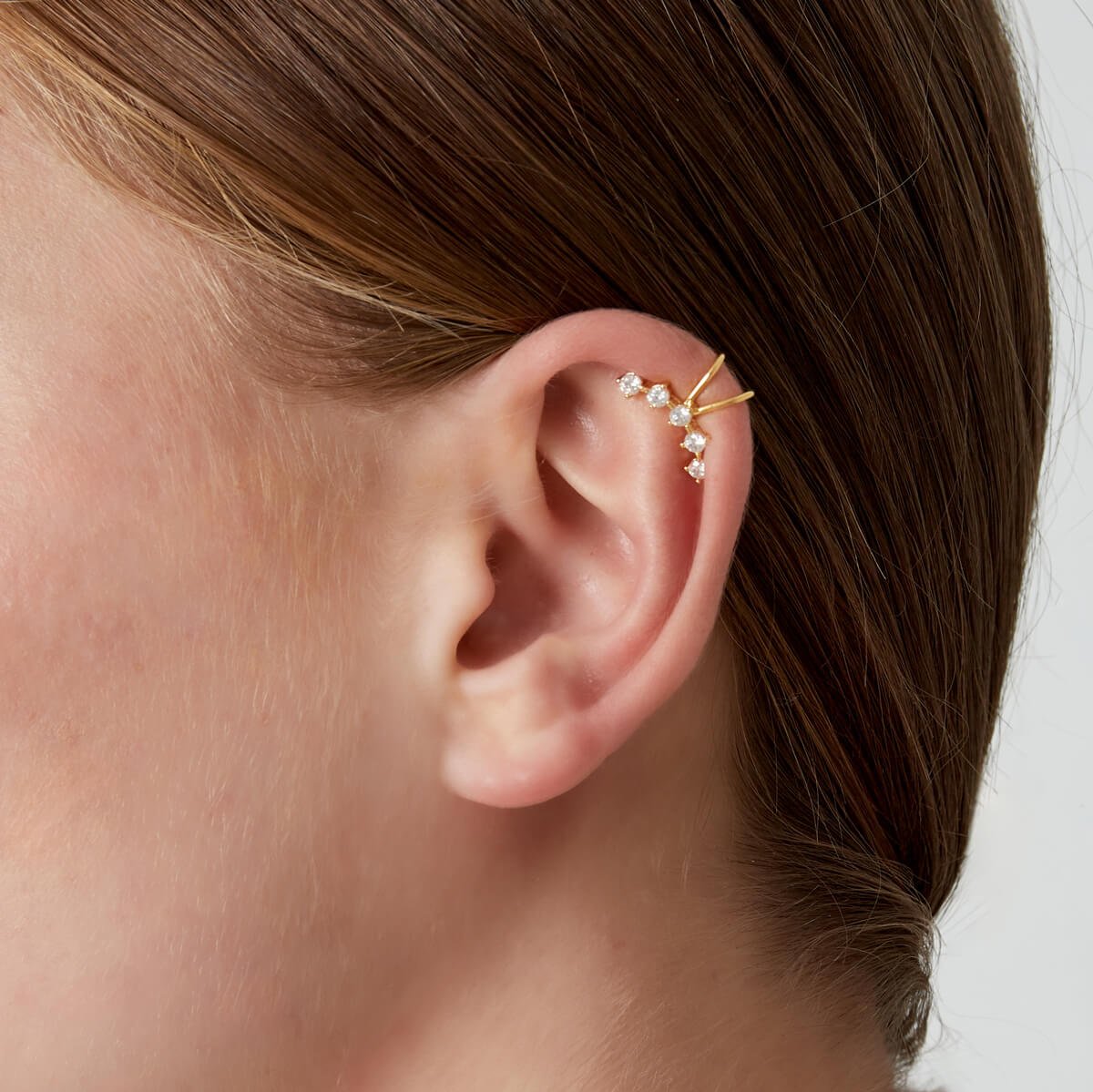 Model draagt een gouden ear cuff zonder gaatjes, ideaal voor feestjes en dagelijks gebruik.