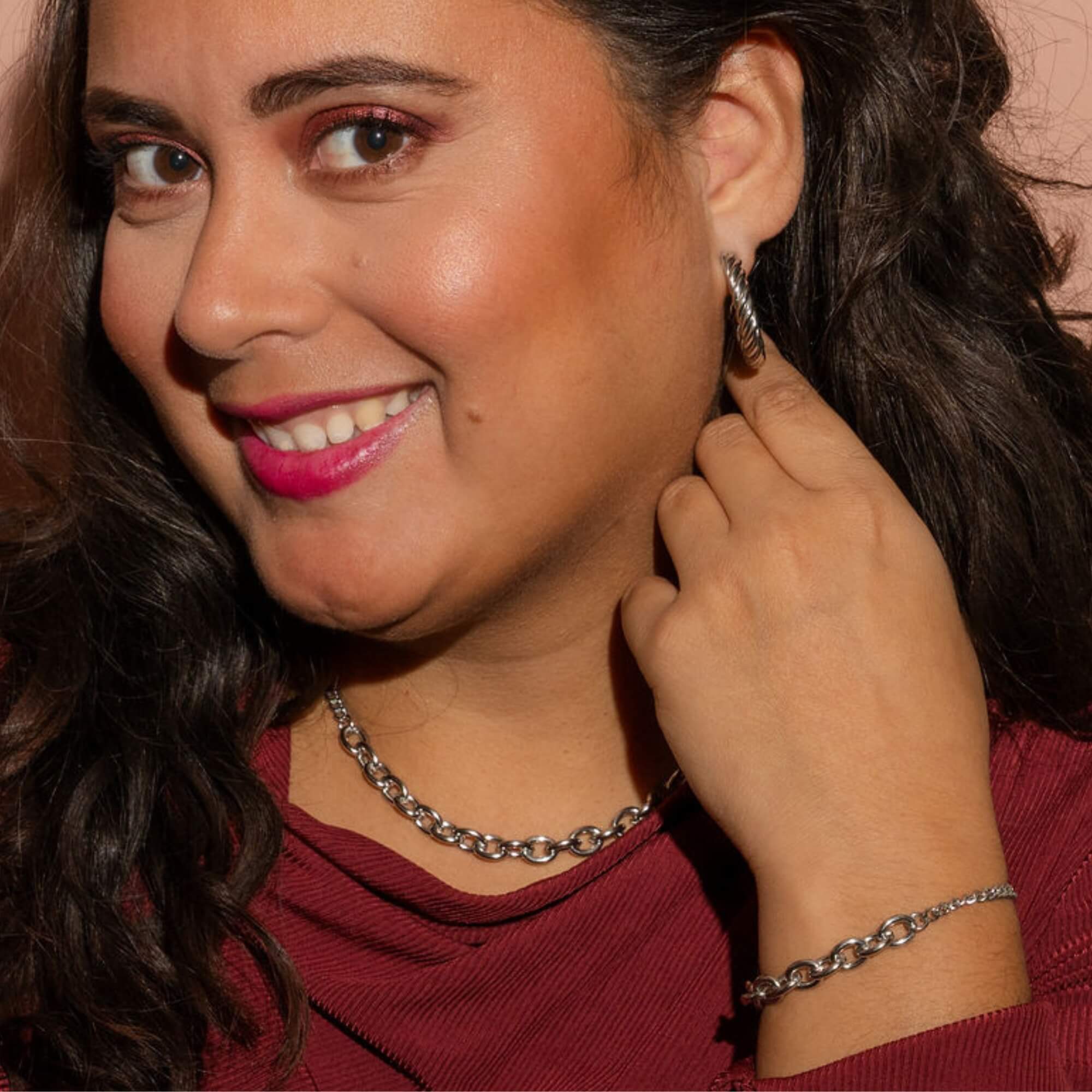 Model draagt Connected in Confidence Sieradenset zilver – Zilveren sieradenset met statement schakels en gedraaide oorbellen. Subtiel krachtig en stijlvol.