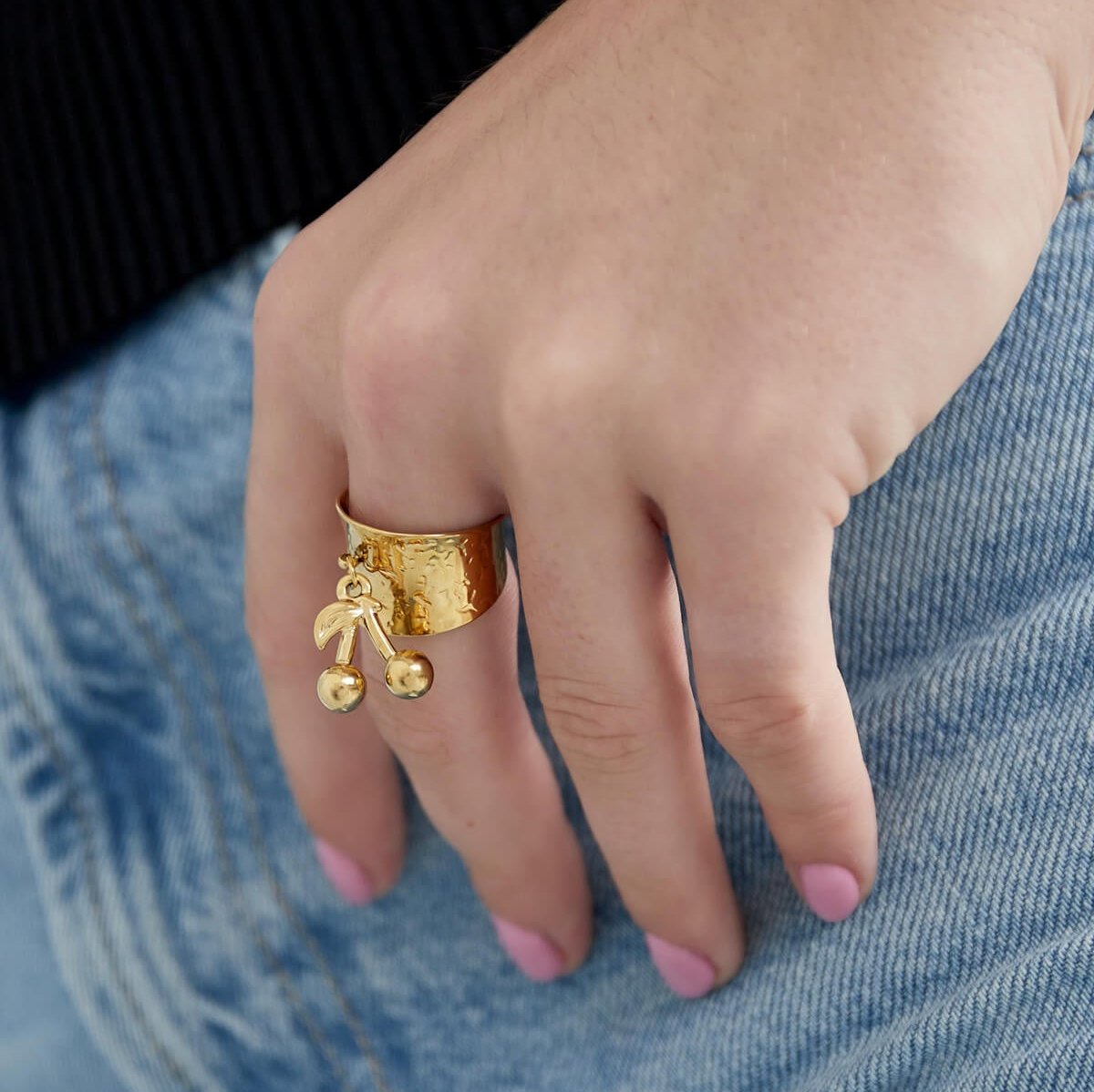 Model draagt de Ring My Cherry een verstelbare gouden ring met kersenbedel, speelse statement ring